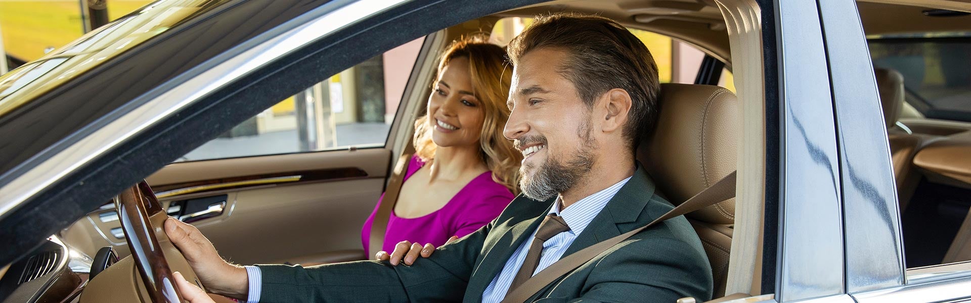 Smiling couple in SUV on Summer Road Trips.